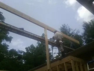 Carpenter setting a ridge beam over a new addition frame — Ice Dam Removal by Roofing Brothers in Lynnwood